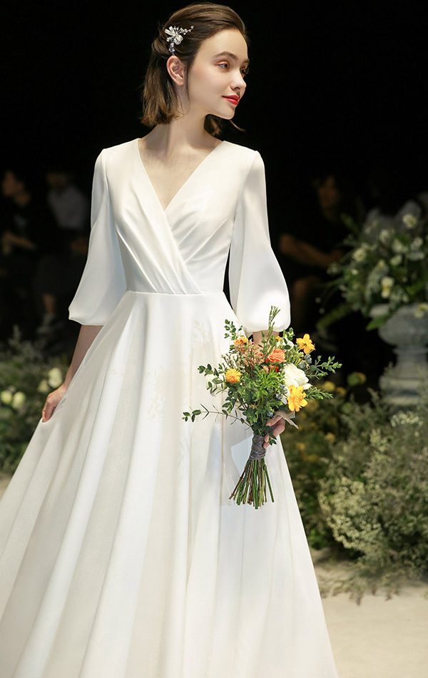 Schlichtes Boho Brautkleid mit Ärmeln, V-Ausschnitt und fließendem Rock bei einer freien Trauung